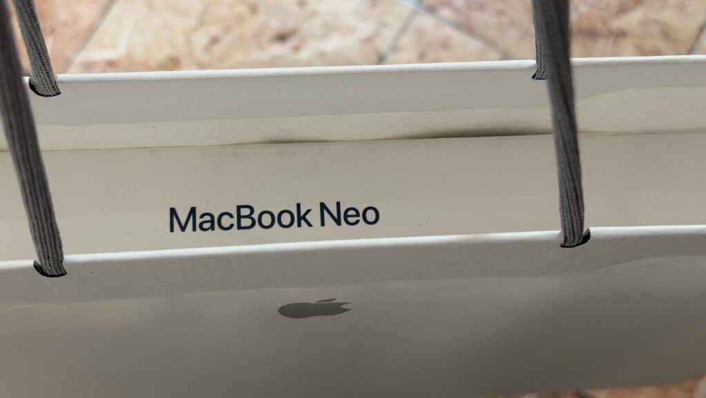 MacBook Neo in an Apple Paper Bag